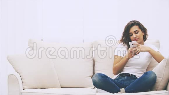 黑人女孩坐在沙发上手里拿着电话发着短信她的朋友加入她带来了很多视频的预览图