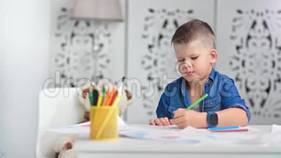 有创意有魅力的男孩子在家画彩色画纸享受艺术视频的预览图