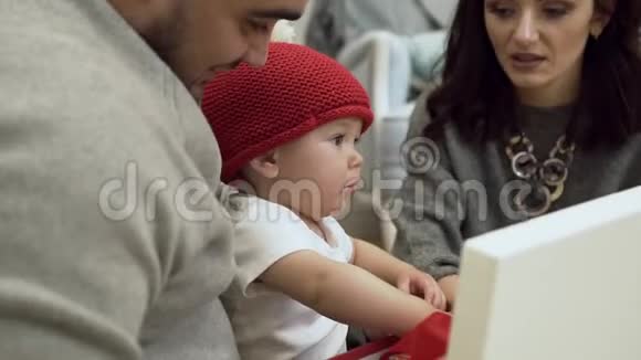 华丽的家庭与令人难以置信的可爱婴儿在筒子帽考虑圣诞礼物视频的预览图