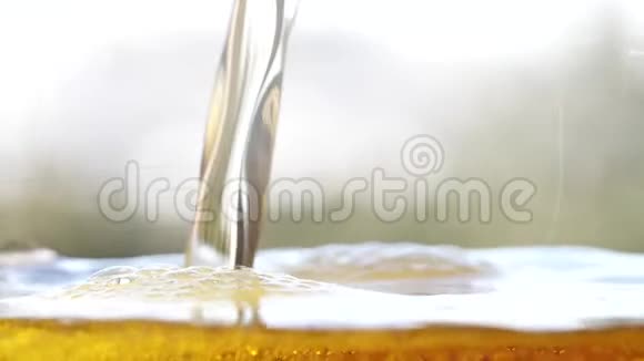 金啤正在倒入玻璃中制造气泡和泡沫视频的预览图