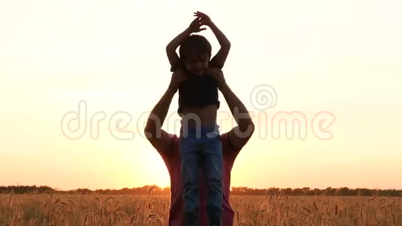 一个男人在夕阳下和一个孩子玩把它扔起来幸福家庭父子关系的概念启发视频的预览图