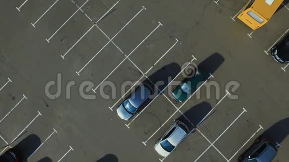 无人机拍摄人们在停车场走来走去在停车场上空飞行视频的预览图