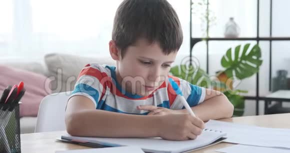 男孩用钢笔思考和写作视频的预览图