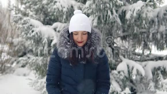 快乐的女人喜欢在冬天的森林里下雪在新鲜空气中行走视频的预览图