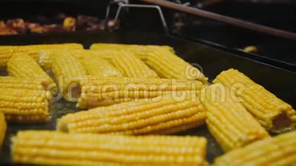 特写烧烤玉米烤在金属表面烤架上烤制的玉米棒视频的预览图