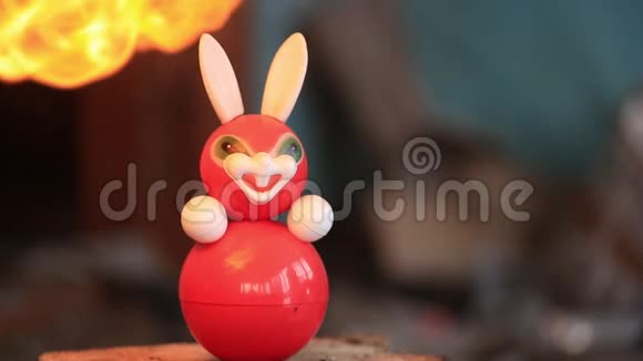 儿童旧塑料玩具兔子从炽热的火焰中融化慢速视频视频的预览图