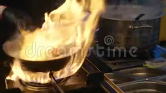 男厨师在厨房餐厅动手做饭慢动作的火焰视频的预览图