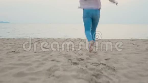 4K快乐的女人在热带海滩上享受暑假赤脚奔向大海带着快乐的感觉跳跃视频的预览图