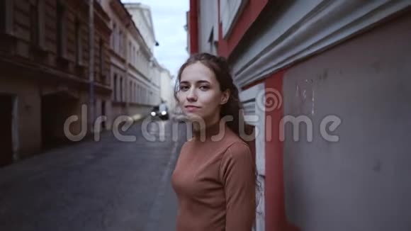 一个年轻迷人的女孩看上去很体贴很尴尬一位卷发的年轻女子站在欧洲视频的预览图