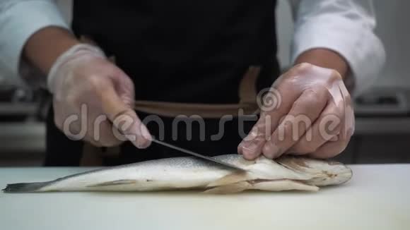 一个男厨师在餐厅的厨房里切鱼视频的预览图