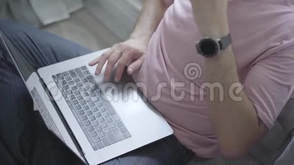 一个不被认出的人坐在窗户旁一边喝咖啡一边在笔记本电脑上打字健康的周末活动视频的预览图