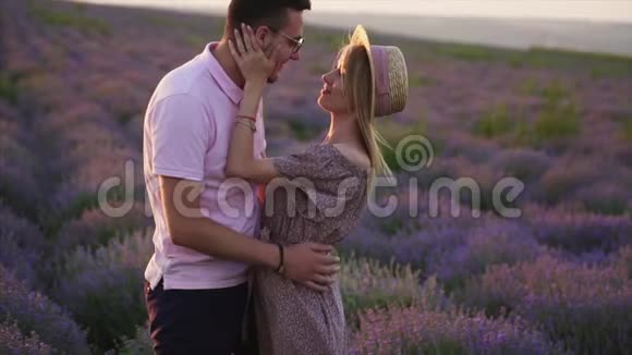 两个情人拥抱在盛开的薰衣草花田特写视频的预览图