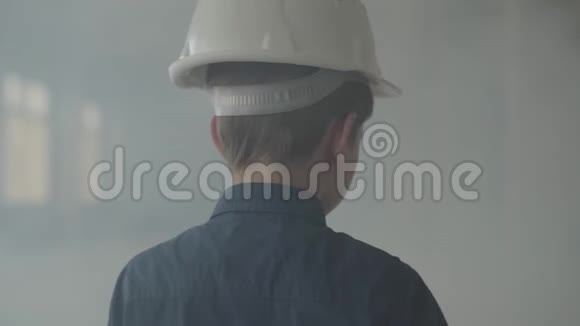 在室内烟雾弥漫的背景下戴着防护头盔的可爱男孩转身看着镜头视频的预览图