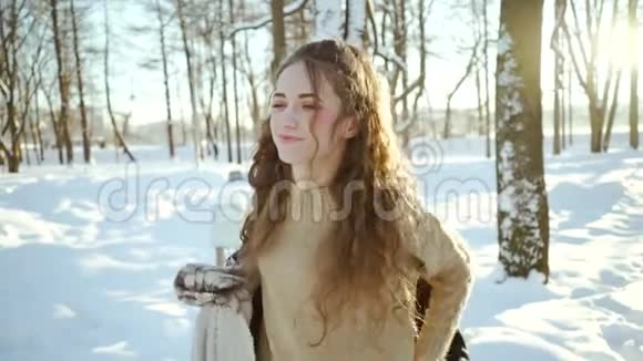 穿毛衣的漂亮女孩穿夹克可爱的年轻女子穿着温暖的衣服在雪堆和视频的预览图