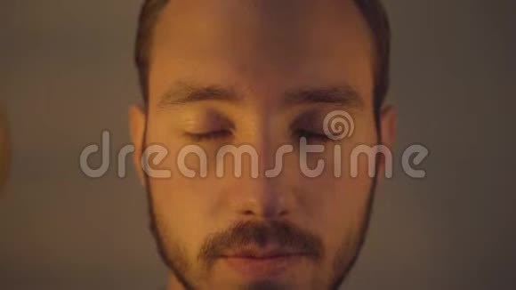 小胡子男的特写肖像脸上贴着两个灯泡看着相机光明和黑暗的概念视频的预览图