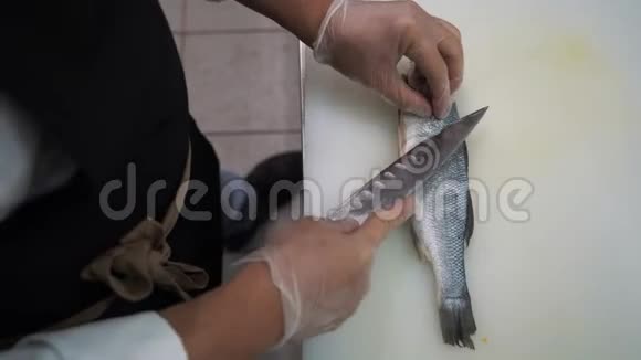 一个男厨师在餐厅的厨房里切鱼视频的预览图