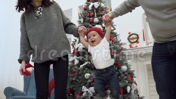迷人的微笑家庭双手抱着可爱的孩子在圣诞节的背景下高高举起他们视频的预览图