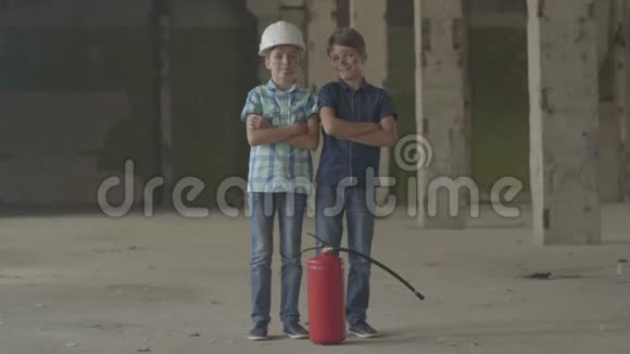 两个脸脏的小男孩站在废弃的大楼里拿着灭火器看着摄像机视频的预览图