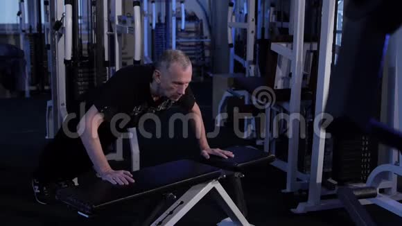 老人把自己从健身房的长凳上推下来复制空间侧视图视频的预览图