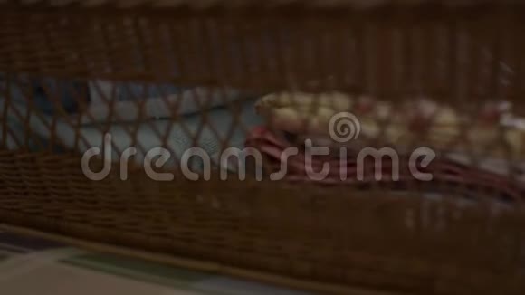 女人正在折叠衣服放进一个木篮子里家庭主妇在卧室做家务活视频的预览图