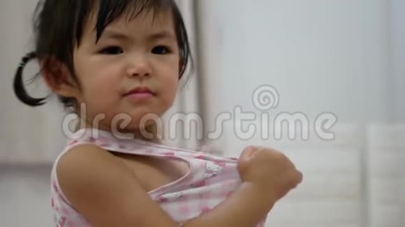 小亚洲女婴骄傲快乐因为她最终能自己成功地穿上衬衫视频的预览图