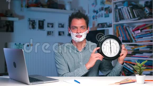 办公室桌上一个脸上有泡沫的男人手里拿着一块手表视频的预览图