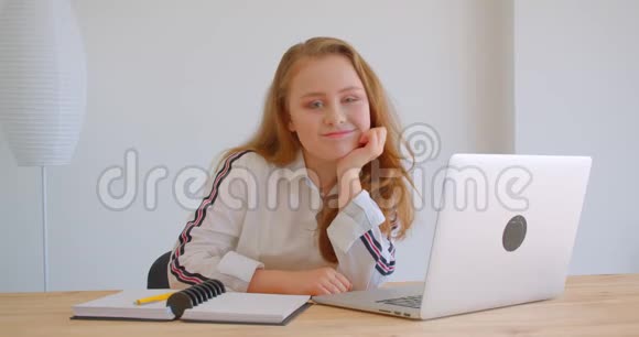 年轻漂亮的白种人女孩的特写镜头用拿铁杆看着镜头在室内开心地笑着视频的预览图