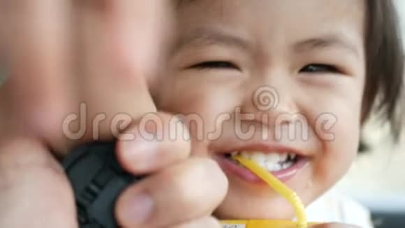 小可爱的亚洲泰国小女孩玩着相机试图触摸它而她正在被拍摄视频的预览图
