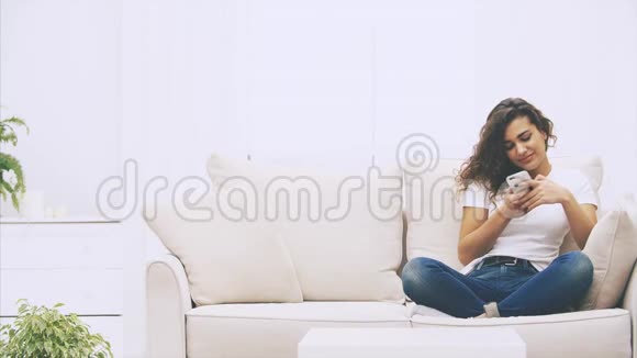 黑人女孩坐在沙发上手里拿着电话发着短信她的朋友加入她带来了很多视频的预览图