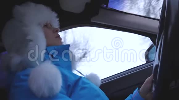 女人在冬天的车里旅行听音乐和跳舞冬天下雪的时候一个女人开车视频的预览图