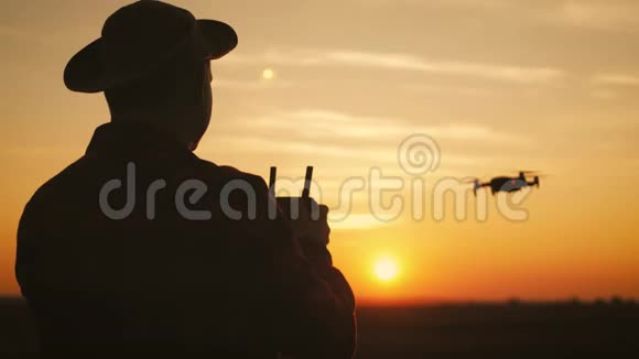 日落时分一个农民在麦田里使用无人机的剪影增加概念技术创新视频的预览图