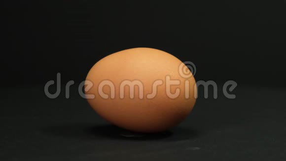 棕色鸡蛋在黑色背景上旋转快关门视频的预览图