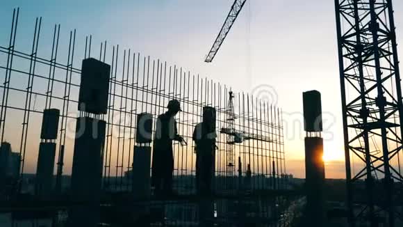 男人在天空背景的建筑工地上工作视频的预览图