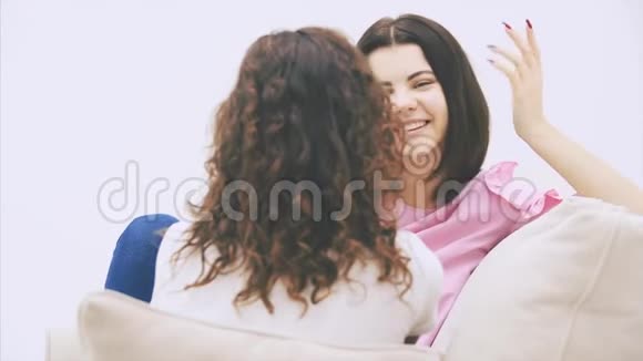 快乐的朋友不小心说话笑坐在沙发上非裔美国人古怪的女孩坐在镜头前视频的预览图