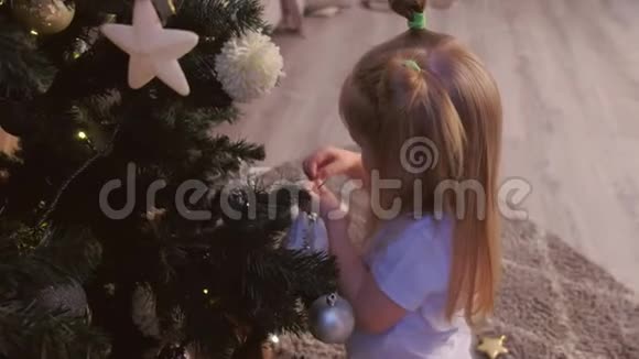 可爱的女孩在家里用玩具装饰人造圣诞树视频的预览图
