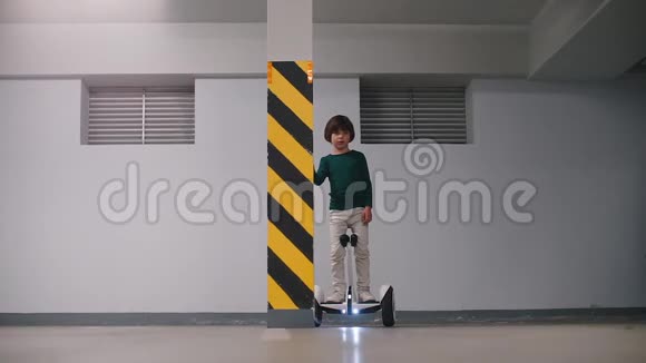 一个男孩把一个陀螺仪停在地下停车场视频的预览图