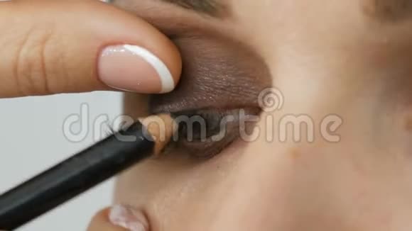 应用眼线的专用铅笔特写晚妆脸和眼睛视频的预览图