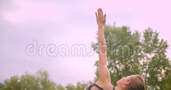 城市公园里一个年轻可爱运动健身的女孩正在做侧木板运动伸展手臂视频的预览图