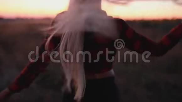 黄昏时分美丽的性感女人在田野里散步视频的预览图