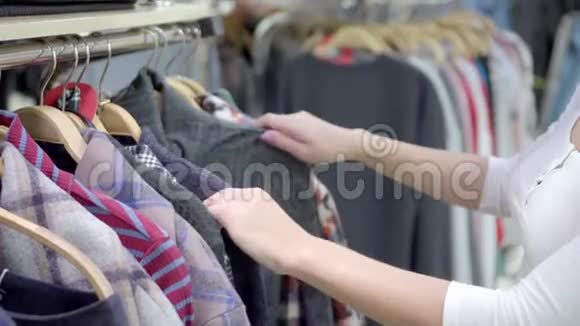女人在购物中心挑选衣服购物一个女人手从商店的衣架上取下衣服五彩缤纷视频的预览图