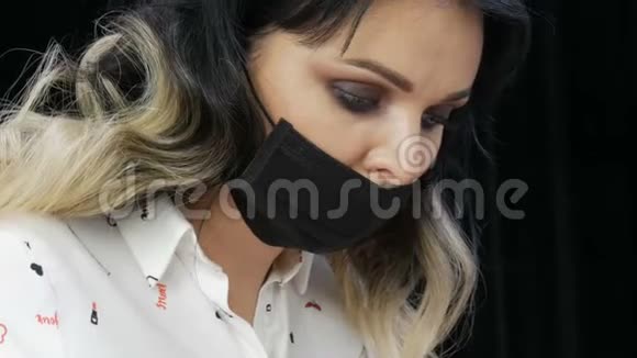 美容师用黑色面具做这个手术一位年轻漂亮女子的特写视频的预览图