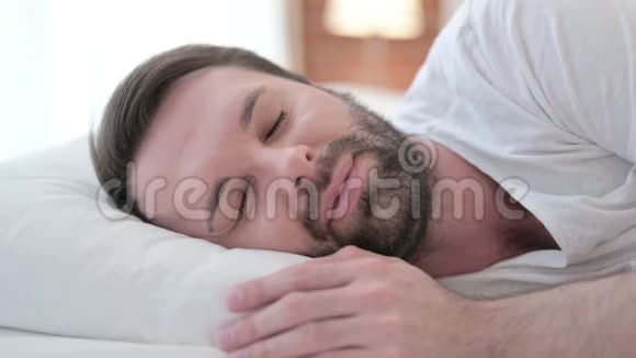 睡不着的胡子青年男子在床上头痛视频的预览图