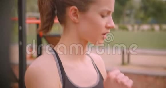 城市户外运动场地上的年轻可爱运动型健身女孩的特写镜头视频的预览图