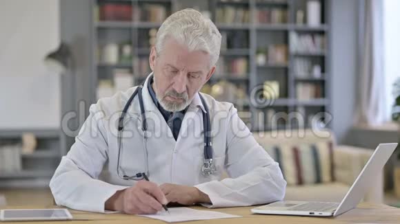 老年医生在诊所做文书工作视频的预览图