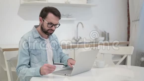 职业胡子青年面临网上支付失败的笔记本电脑视频的预览图