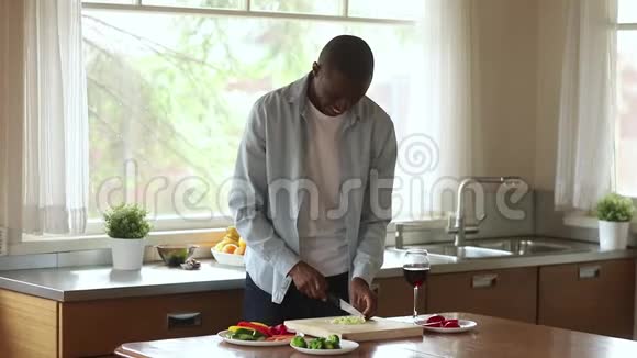 微笑着为厨房里的沙拉切菜的黑人千禧一代视频的预览图