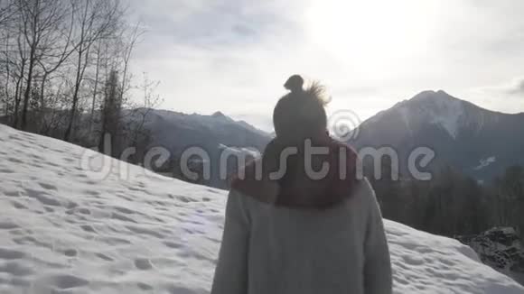 女孩走到夕阳西下的冬山稳定的跟踪拍摄视频的预览图