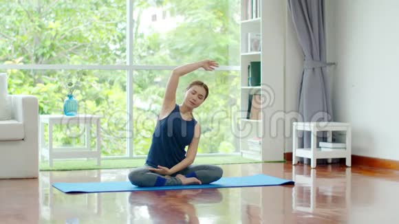 年轻的美女在家训练瑜伽视频的预览图