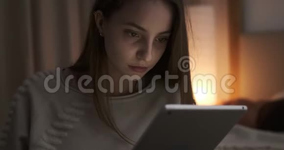 体贴的少女晚上用数码平板电脑视频的预览图