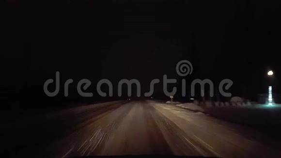 夜间在农村路上下雪时开车冬季的POV雪和雪花的司机视角视频的预览图